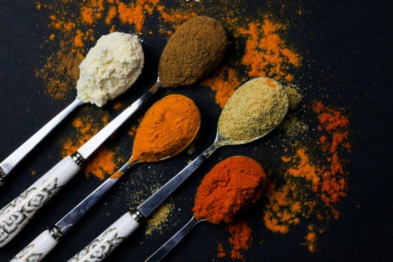 Colorful various herbs and spices for cooking on dark background
