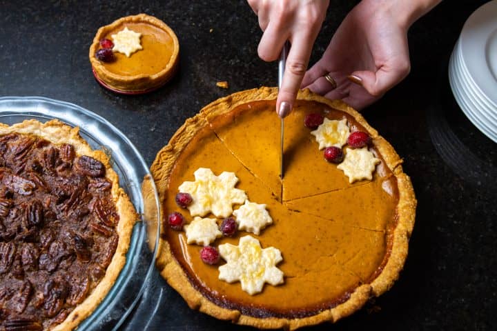 Woman cutting pumpkin pie